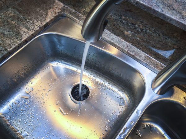 Hand Inspecting Bunch of Hair Trapped at Bathroom Drain Outlet